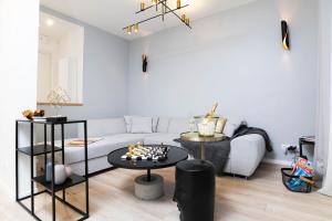 伊西莱穆利诺Appartement Design&Nouveau, ParisExpo Pte-de-Versaille, Parking&Netflix的客厅配有白色的沙发和桌子