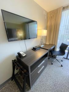 檀香山Aqua Palms 306 condo的酒店客房设有一张桌子,墙上配有电视