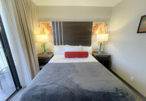 檀香山Aqua Palms 306 condo的一间卧室配有一张红色枕头的床
