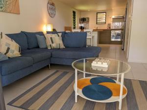耐莉湾Canopy 5 Chalet的客厅配有蓝色的沙发和玻璃桌