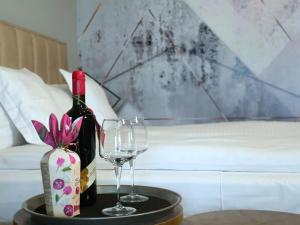 克卢日-纳波卡Eriss Studio Suite - OZone building apartment的桌子上放有一瓶葡萄酒和两杯酒