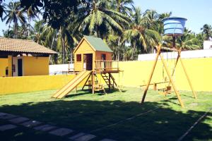 皮亚萨布苏Viana Praia Hotel的一个带滑梯、房子和棕榈树的游乐场