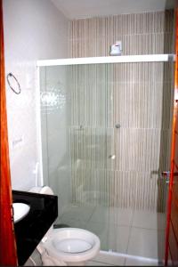 皮亚萨布苏Viana Praia Hotel的带淋浴、卫生间和盥洗盆的浴室