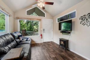 阿什福德New Tiny Home Steps Away From Mt. Rainier的客厅设有真皮沙发和壁炉