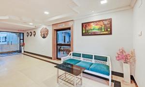 普里Treebo Trend Sidhartha International Baliapanda的客厅配有长凳和墙上的绘画