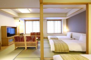 出云市Oyado Tsukiyo no Usagi的酒店客房设有两张床和电视。