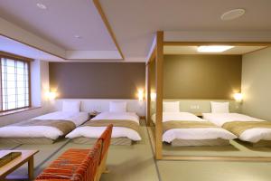出云市Oyado Tsukiyo no Usagi的带四张床和镜子的客房