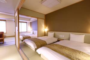 出云市Oyado Tsukiyo no Usagi的酒店客房,设有两张床和镜子