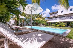 康隆尼角曼荼罗莫里斯度假屋的度假村旁的游泳池配有躺椅和遮阳伞
