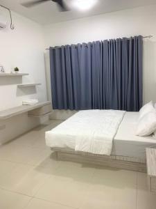 瓜拉丁加奴4A Icon Residence的一间卧室配有床和蓝色窗帘