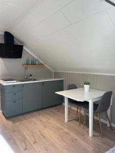 拉尔维克Modern, small appartment的厨房配有桌椅和水槽。