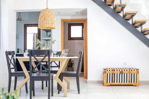 罗德岛卡利地亚Villa Kora的用餐室配有木桌和黑椅子