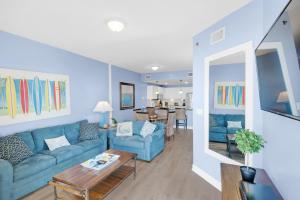巴拿马城海滩Grand Panama 2-705的客厅配有蓝色的沙发和桌子
