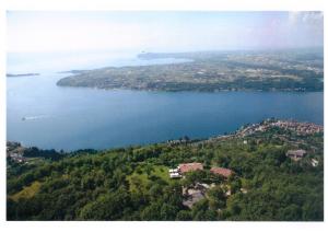 萨罗La FIOCCHINA - Magic Place - apartments & studios in Garda Lake - countryside farmhouse, inside the middle of the lake的一大片水体的空中景观