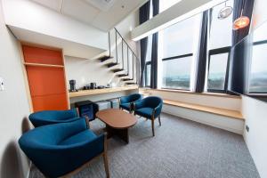 首尔首尔奥林匹克公园酒店的一间办公室,配有蓝色的椅子和一张桌子,窗户