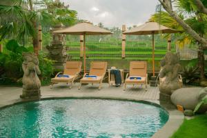 乌布Govala Ubud Villas & SPA的庭院内一个带椅子和遮阳伞的游泳池