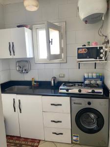 沙姆沙伊赫Delta Sharm Apartment 156 flat 102的厨房配有炉灶和洗衣机。