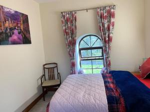 卡洛Cut Limestone Apartment Riverside Lodge的一间卧室设有一张床、一个窗口和一把椅子