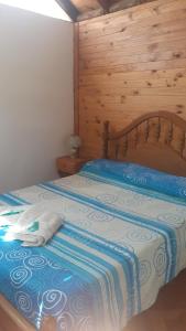 卢汉德库约Cabañas El Abuelo Alfredo的一间卧室配有一张木墙床