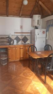 卢汉德库约Cabañas El Abuelo Alfredo的厨房配有木桌、桌子和冰箱。