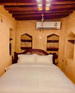 尼兹瓦Jawharat Alaqar Inn نزل جوهرة العقر的卧室配有带白色枕头的大床