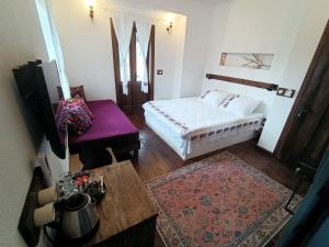 DoğanbeyPuli Stone Houses的酒店客房,配有一张床铺和一张桌子,还有一间客房