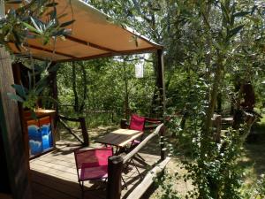 佩内拉Green Man yurt的木制甲板配有两把椅子和一张桌子