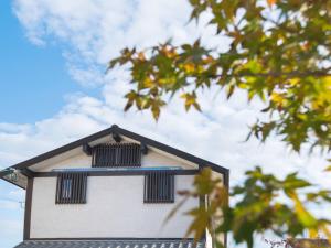 高松若叶屋旅馆的白色的建筑,上面有黑色的窗户