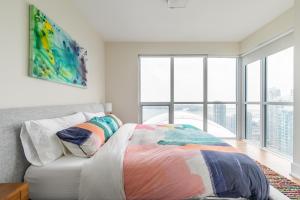 多伦多多伦多市中心云9公寓的一间卧室配有一张带彩色毯子的床