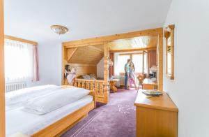 欣特察尔滕IMbery Hotel & Restaurant Hinterzarten的一间卧室配有两张床,而人站在房间里