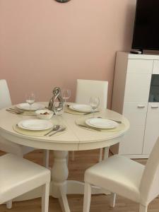 维也纳Prater Zentrum的一张带盘子和酒杯的白色桌子
