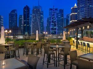 迪拜Armada Avenue Hotel - formerly Armada BlueBay Hotel的一个带桌椅的屋顶露台,享有城市天际线