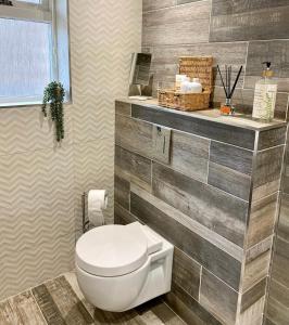 罗斯伯里No. 3 Tomlinsons Apartments的浴室设有白色卫生间和瓷砖墙。