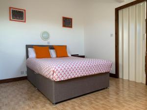 曼彻斯特Manchester Stay Hotel的一间卧室配有带橙色枕头的床