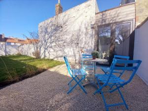 奥斯坦德Dunes et Mer - Terrace, garden and free parking space的庭院里设有两把蓝色的椅子和一张桌子