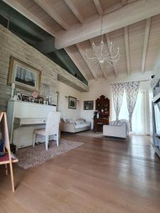 巴多利诺Villa Claudia的一个带钢琴和吊灯的大客厅