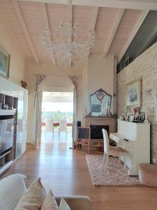 巴多利诺Villa Claudia的客厅配有吊灯和桌椅