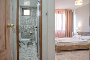 RakovoDaulite boutique hotel的一间卧室配有一张床,浴室设有卫生间