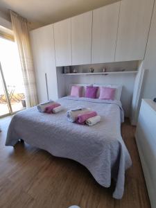 圣雷莫Il Paradiso del Relax Chambres d'hotes Affittacamere room with sea view的卧室配有一张带粉红色枕头的大床