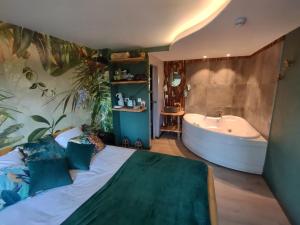 萨乌丁Domaine De La Carrauterie by Terre Insolite的一间卧室配有浴缸和一张带枕头的床。