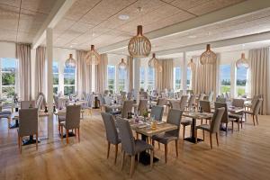 博尔加内斯Hotel Hamar的用餐室设有桌椅和窗户。