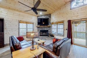 索蒂纳科奇Cozy Bear Cabin #2的客厅配有皮革家具和壁炉