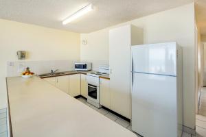 卡伦德拉海角风景公寓酒店的白色的厨房配有冰箱和水槽