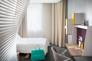 里昂里昂拉法叶蓬奥考酒店的酒店客房,配有床和蓝色袋子