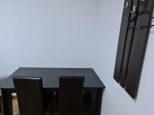 克拉约瓦Hotel Safta Residence的一张黑色餐桌和两张黑色椅子