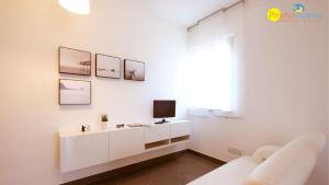 皮内托Mango 2 Pineto Vacanza的白色的客厅,墙上配有电视