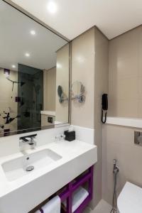 迪拜Studio M Al Barsha Hotel by Millennium的浴室设有白色水槽和镜子