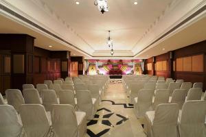 钦奈拉达丽晶，金奈酒店的一间大房间,配有白色椅子和舞台