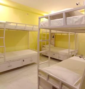 勒克瑙Hashtag Traveler's的客房设有三张双层床和黄色墙壁