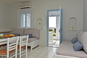 克里希阿克提Tonia Apartments Paros的厨房以及带沙发和桌子的客厅。